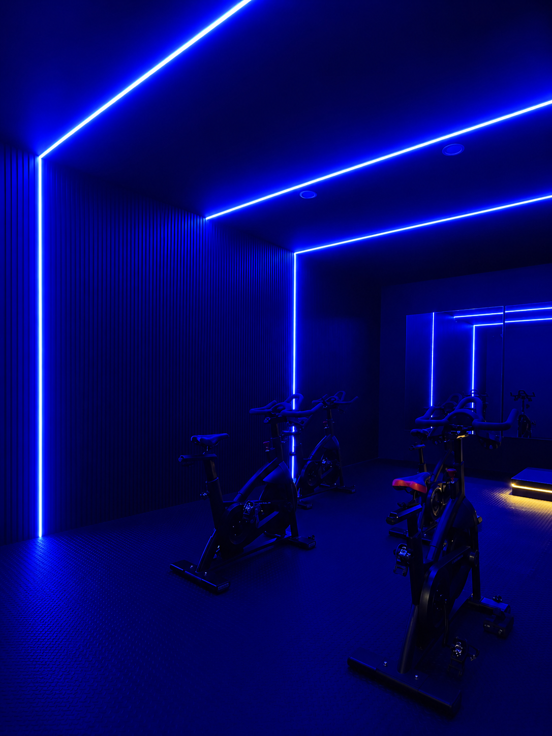 Core Ride studio interior lit by blue neon strips with rows of indoor cycling bikes